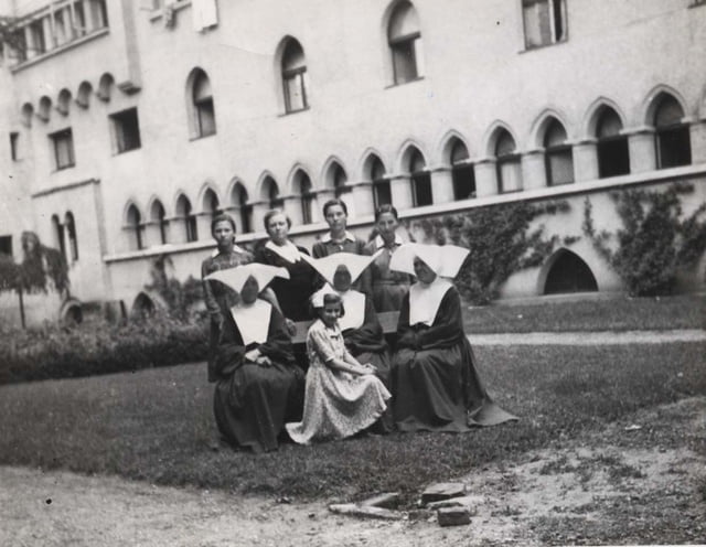 Marlaine Khan la rescapée(avec un ruban dans les cheveux assise devant) avec les soeurs du monastère. Credit: COLL.YAD