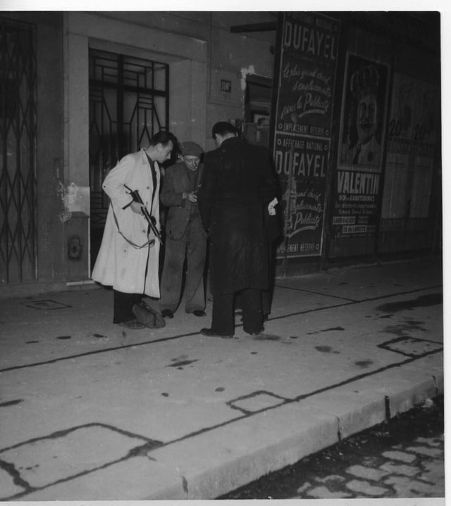 André CAILLOU en imperméable blanc